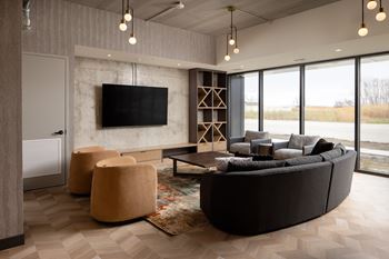 A modern living room with a large couch, a television, and a rug.